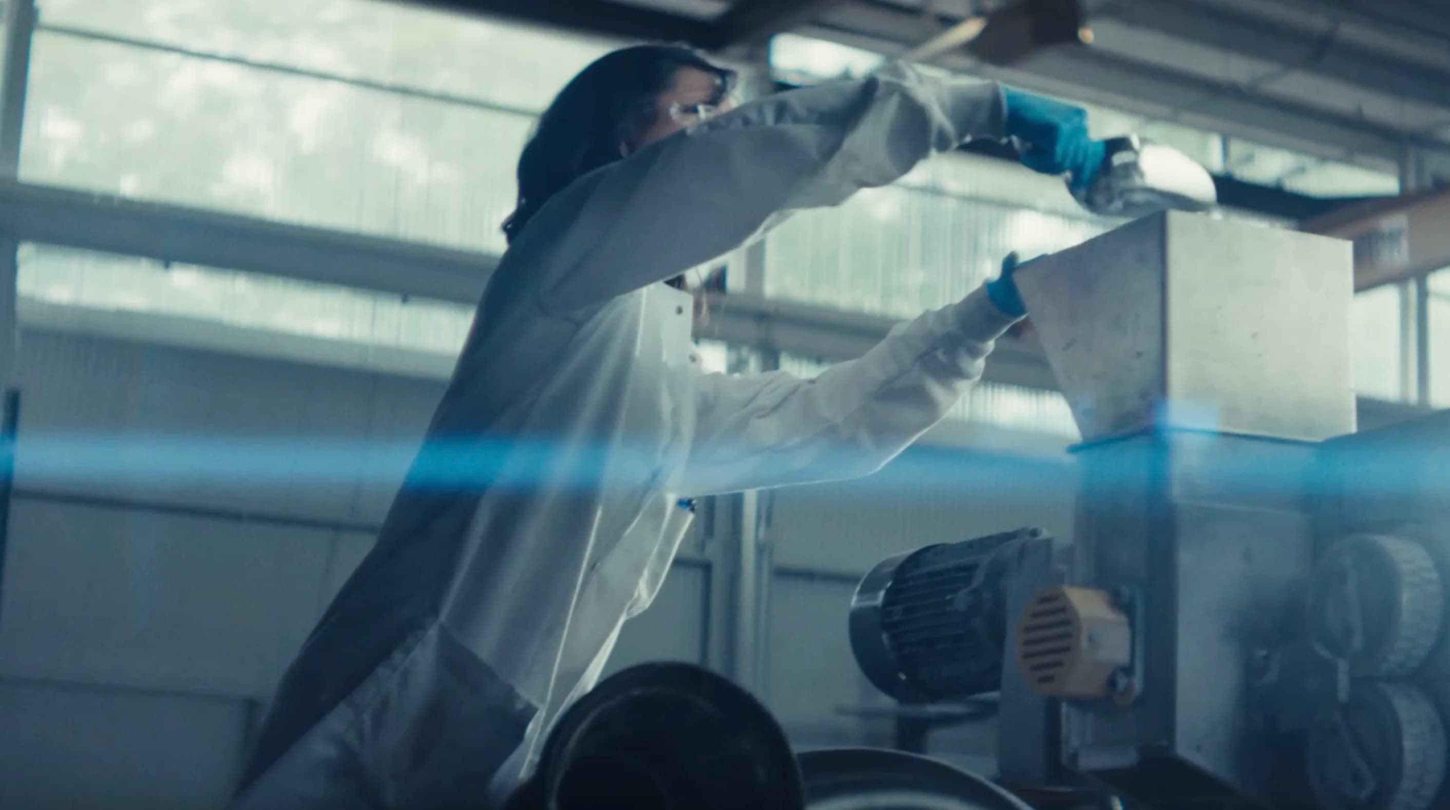 Still from the Solcoa brand video: a technician in protective clothing working at production equipment